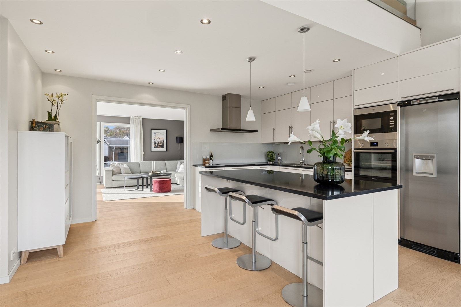 Innredning med høyglansfronter og steinbenkeplate gir et stilrent kjøkken. Galleribilde