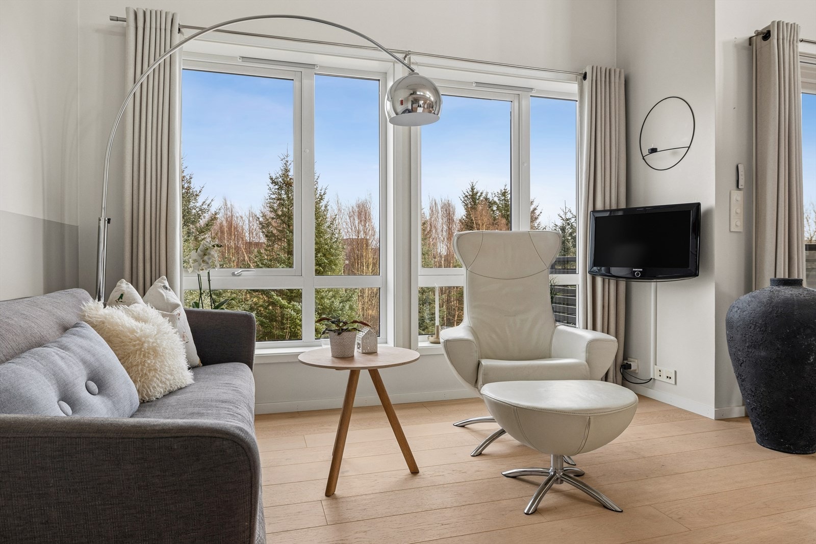 Gulv i parkett og store vinduer gir rommet et lyst preg med utsyn mot naturen. Galleribilde