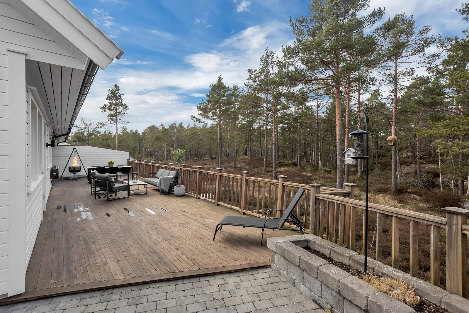 Stor solrik terrasse med rekkverk og levegg mot nabo. Galleribilde