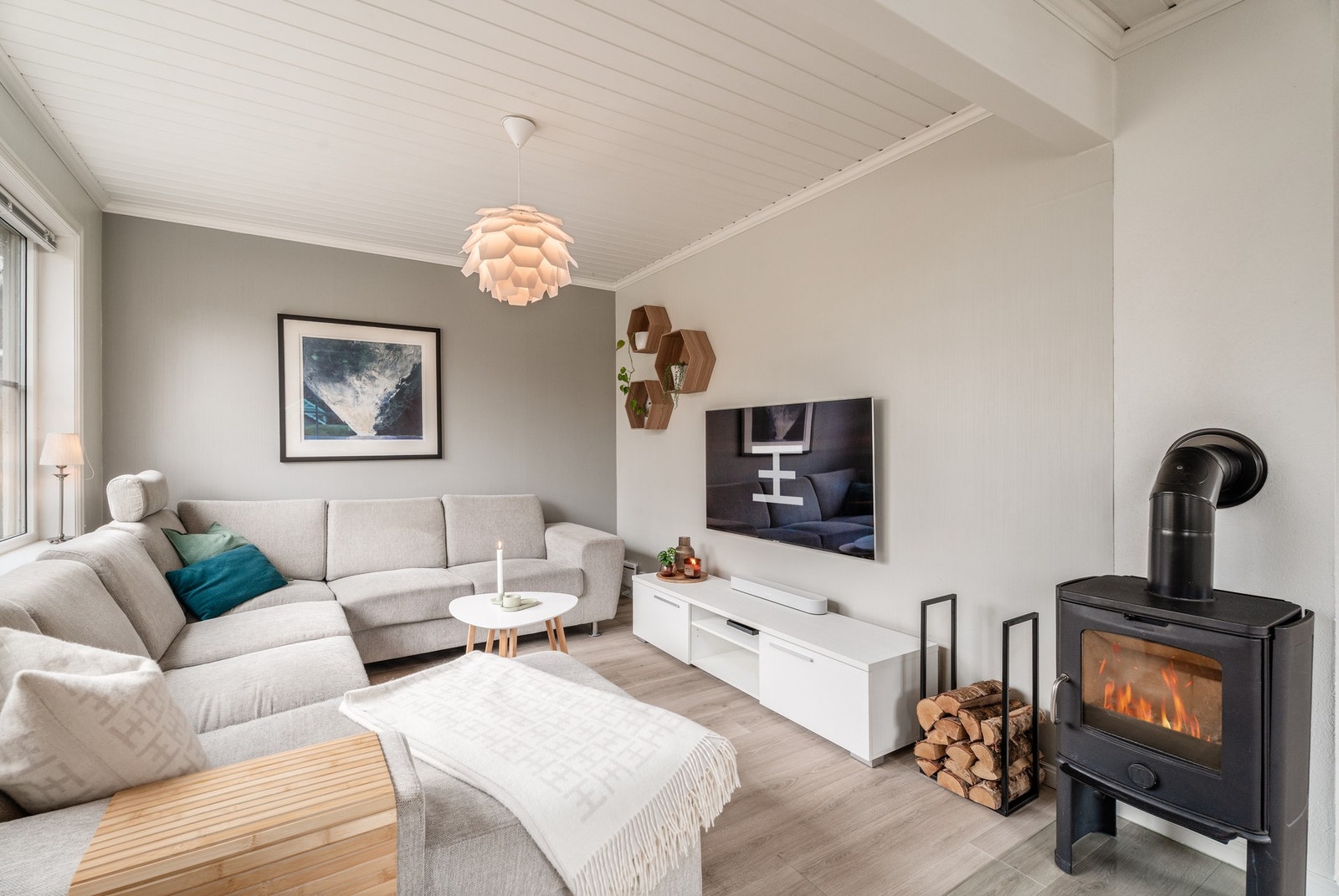 Flott stue med vinkel utforming, her er det oppvarming via varm og god vedovn. Galleribilde