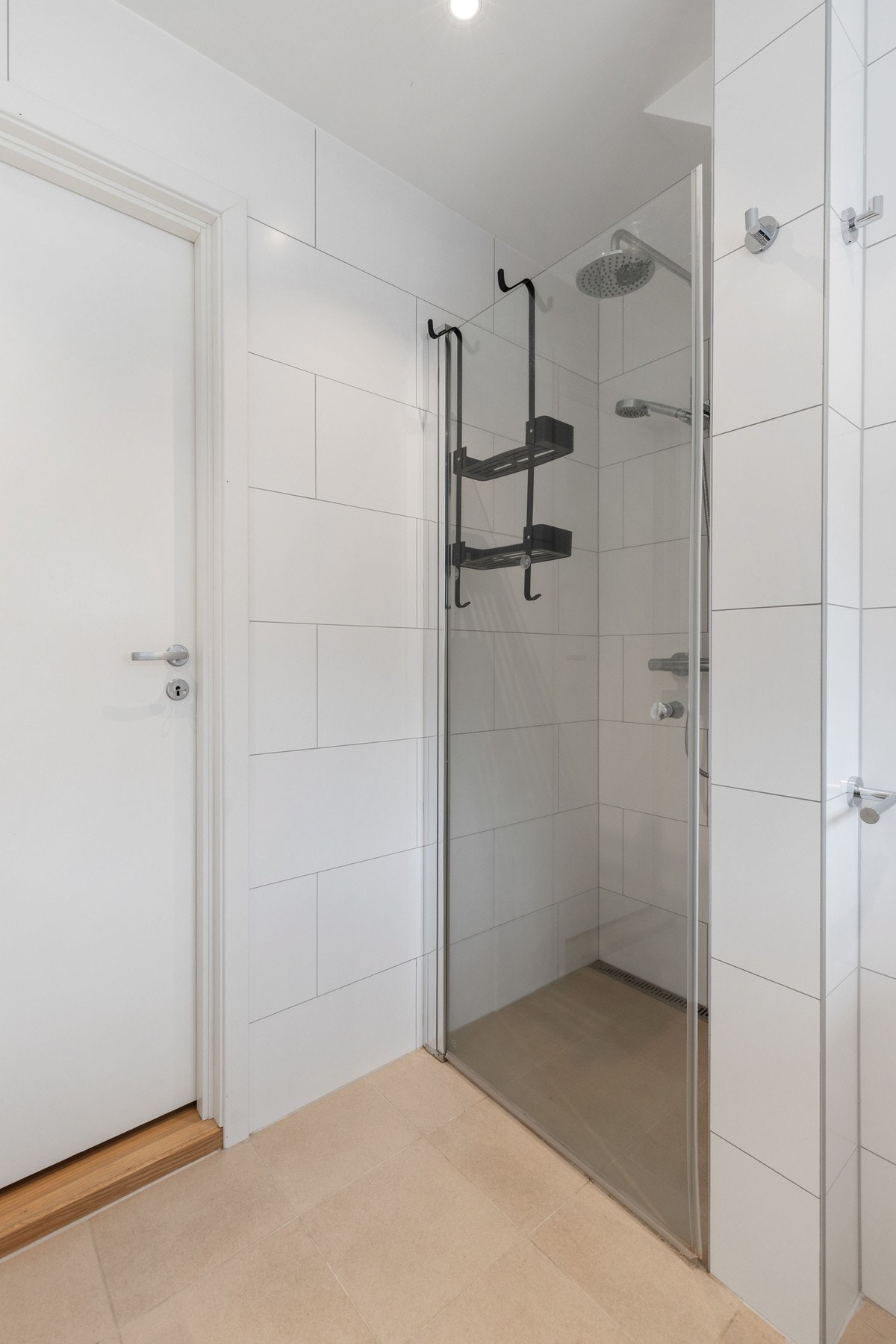 Videre har badet dusjnisje med glassdør og vegghengt dusjarmatur med både hånddusj og regndusj Galleribilde