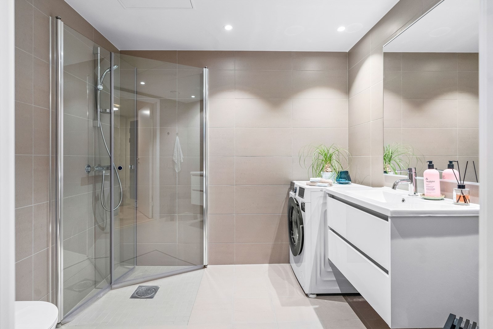 Badet er delikat innredet med store fliser, gulvvarme og downlights. Galleribilde