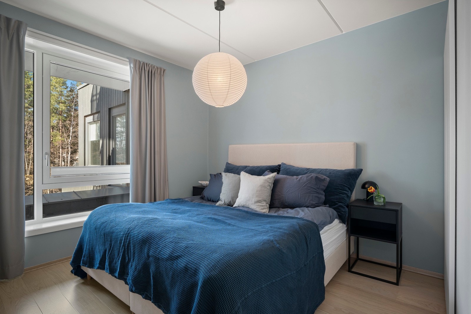 Hovedsoverommet er malt i en lys, delikat blåfarge. Her er det god plass til en dobbeltseng med nattbord. Garderobeskap langs med den ene veggen sørger for godt med oppbevaring. Galleribilde