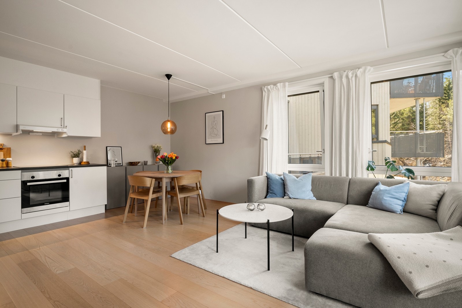 Stuen er lys og åpen med store vinduer som sørger for rikelig med naturlig lysinnslipp. Galleribilde