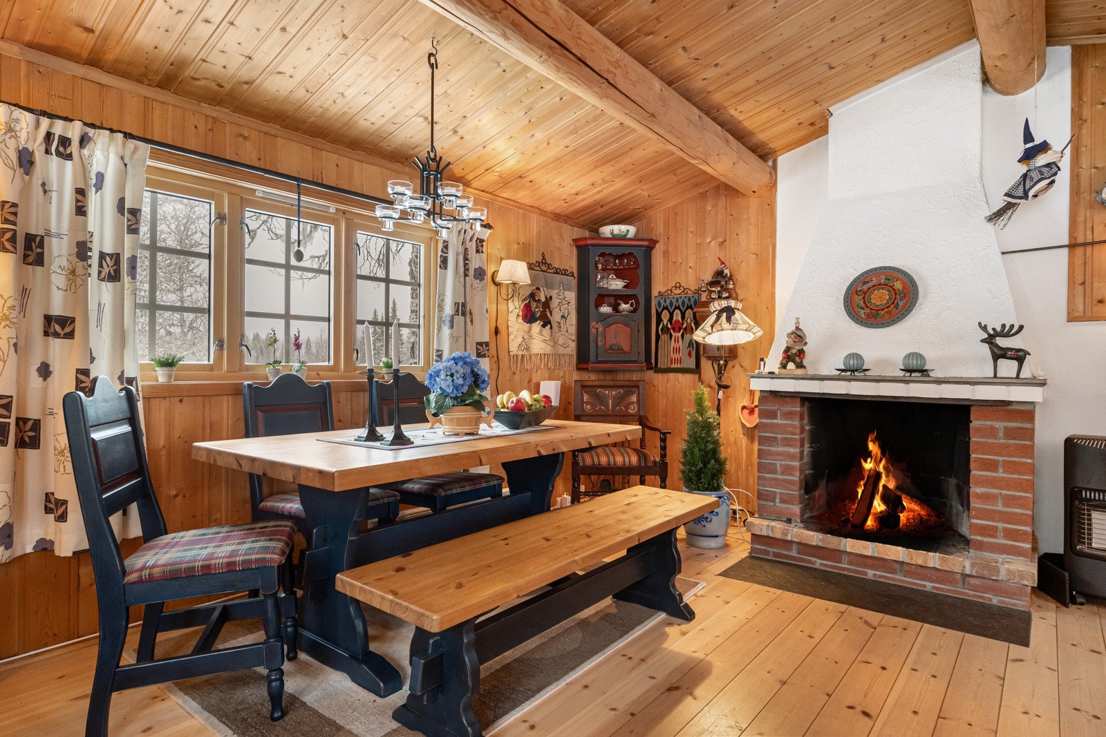Stuen er et ekte samlingspunkt i hytta, med overflater bestående av varme furugulv og panel både på vegger og i tak Galleribilde