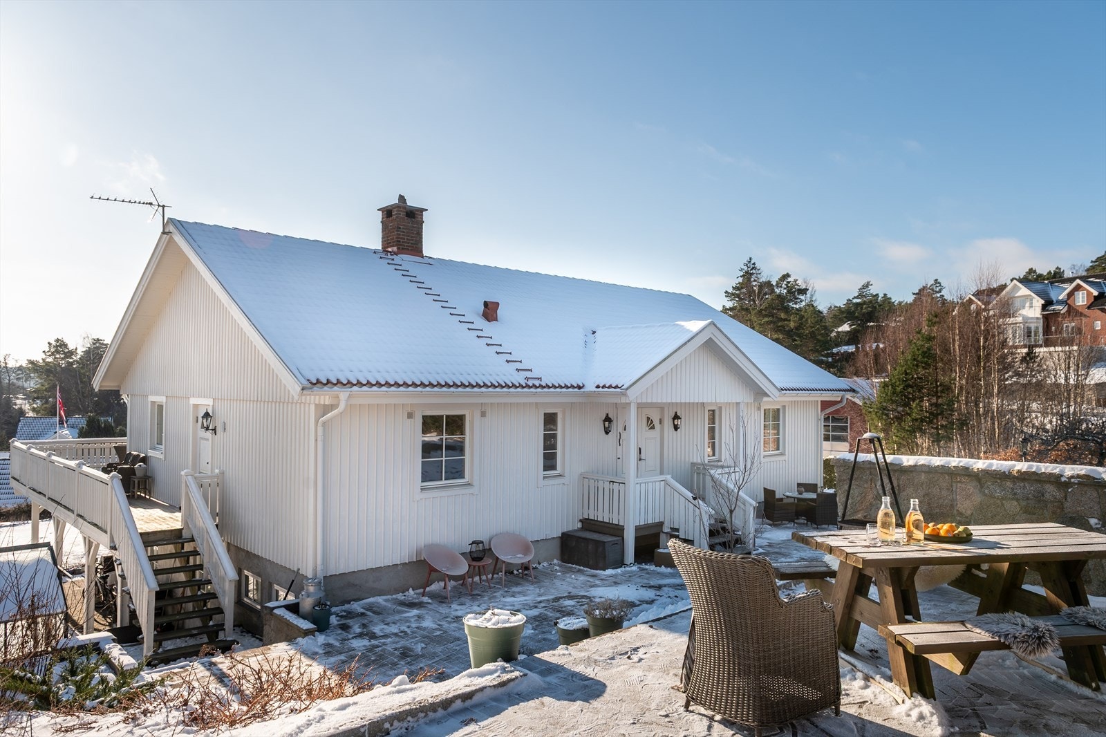 Litt høyere og tilbaketrukket finner du en markterrasse i naturstein, med oppmurte vegger og utepeis _ en praktfull uteplass som står i knivskarp konkurranse med de andre om å være den mest attraktive plassen. Galleribilde