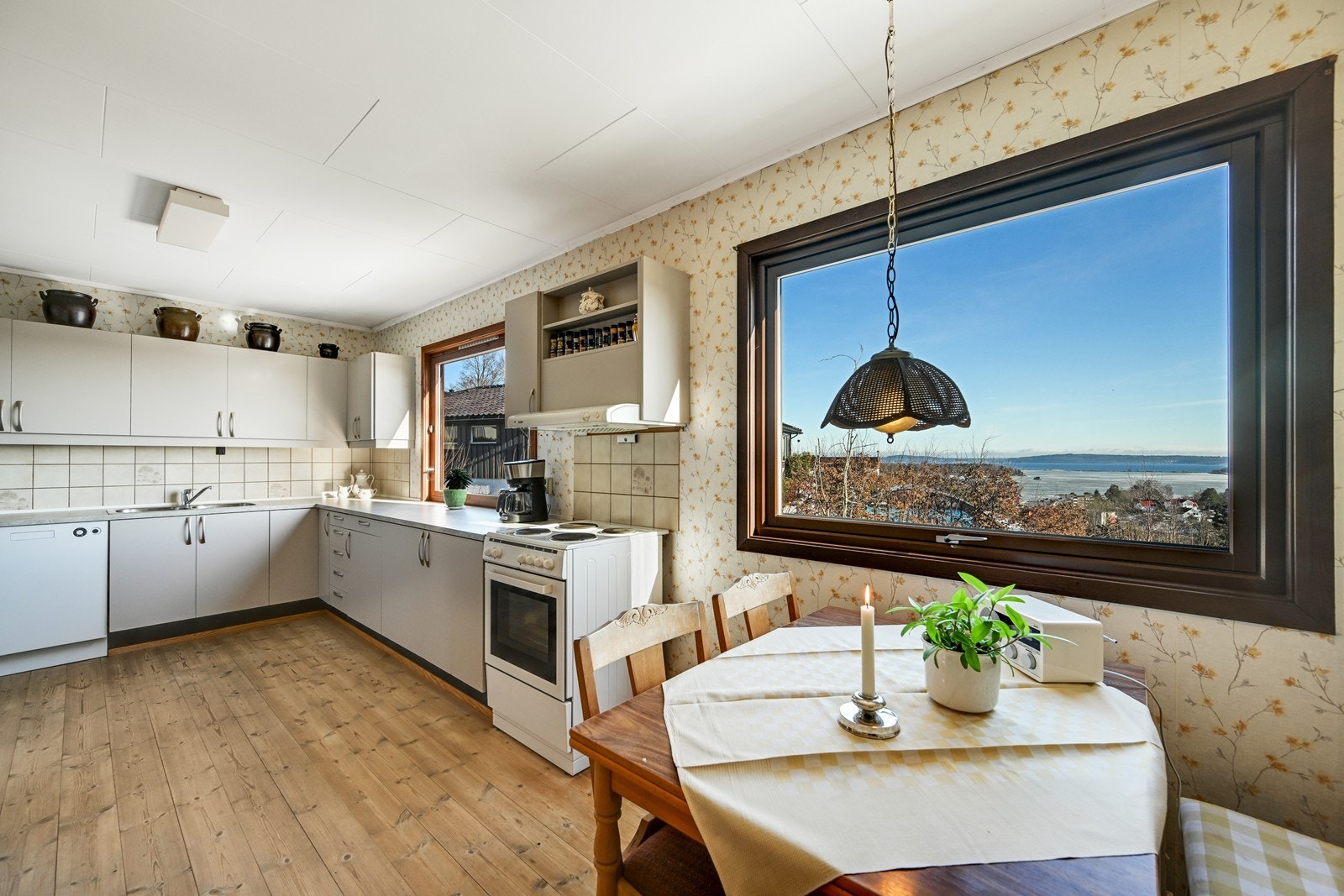 Kjøkken har en fin plassering i boligen med to store vinduer med nydelig utsikt til fjorden. Galleribilde