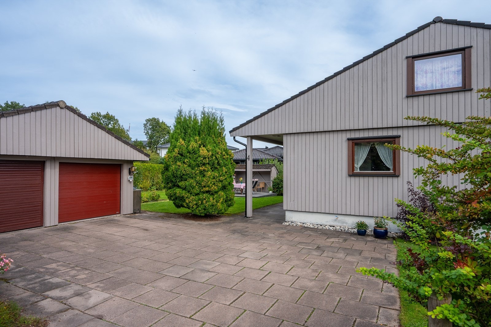 Romslig hellelagt innkjørsel og gårdsplass. Galleribilde