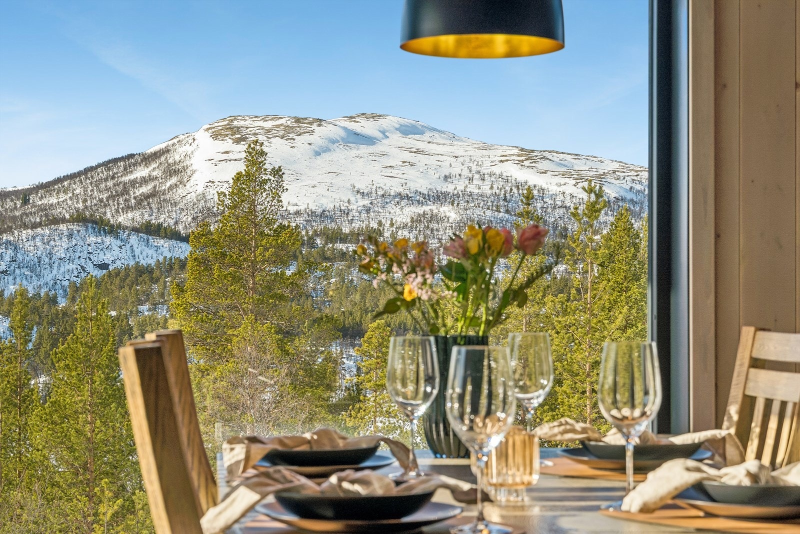 De store vinduene rammer inn fjellandskapet og gir rikelig med naturlig lys. Galleribilde