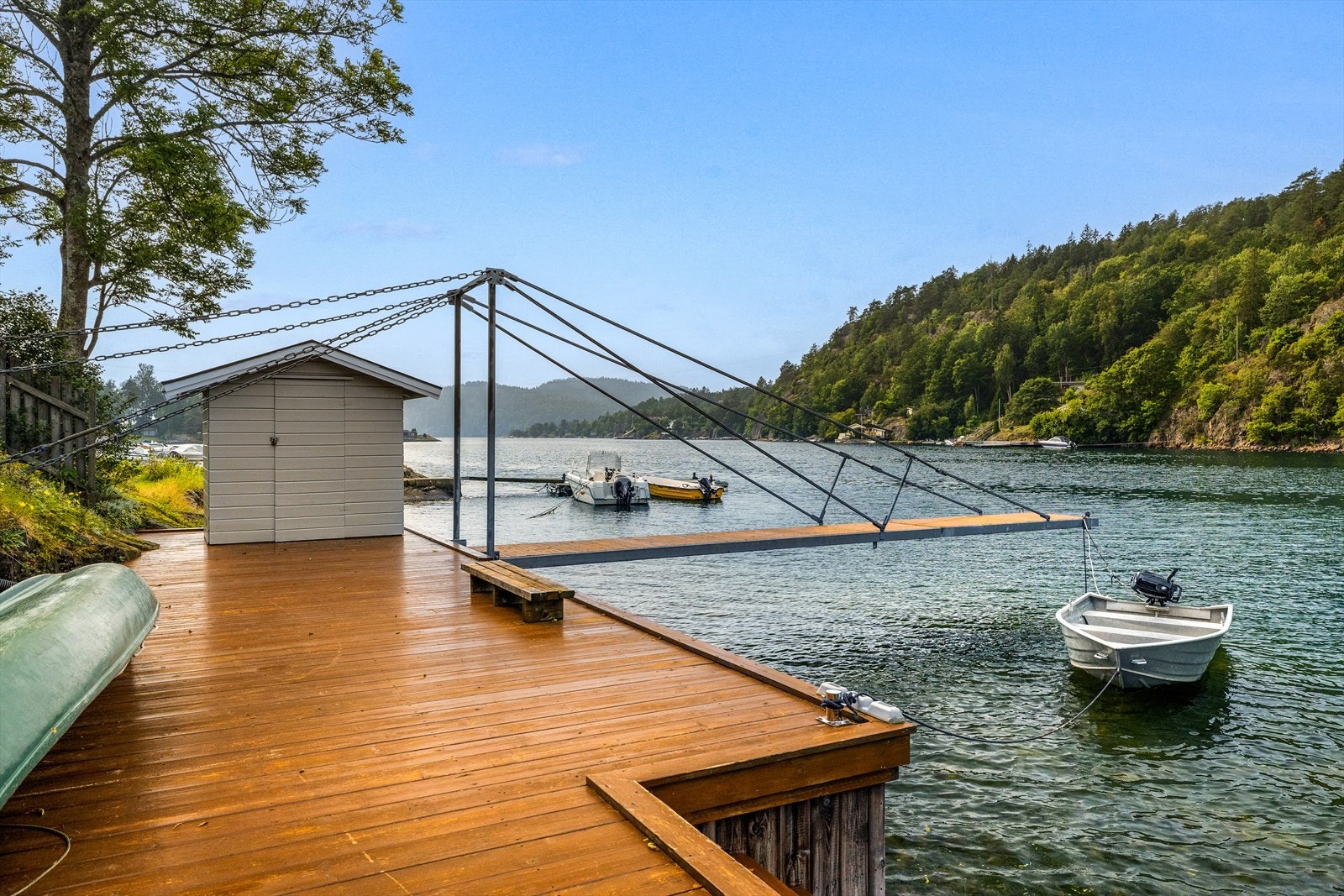 På bryggen står en enkel, uisolert sjøbod for oppbevaring av fiske- og båtutstyr Galleribilde