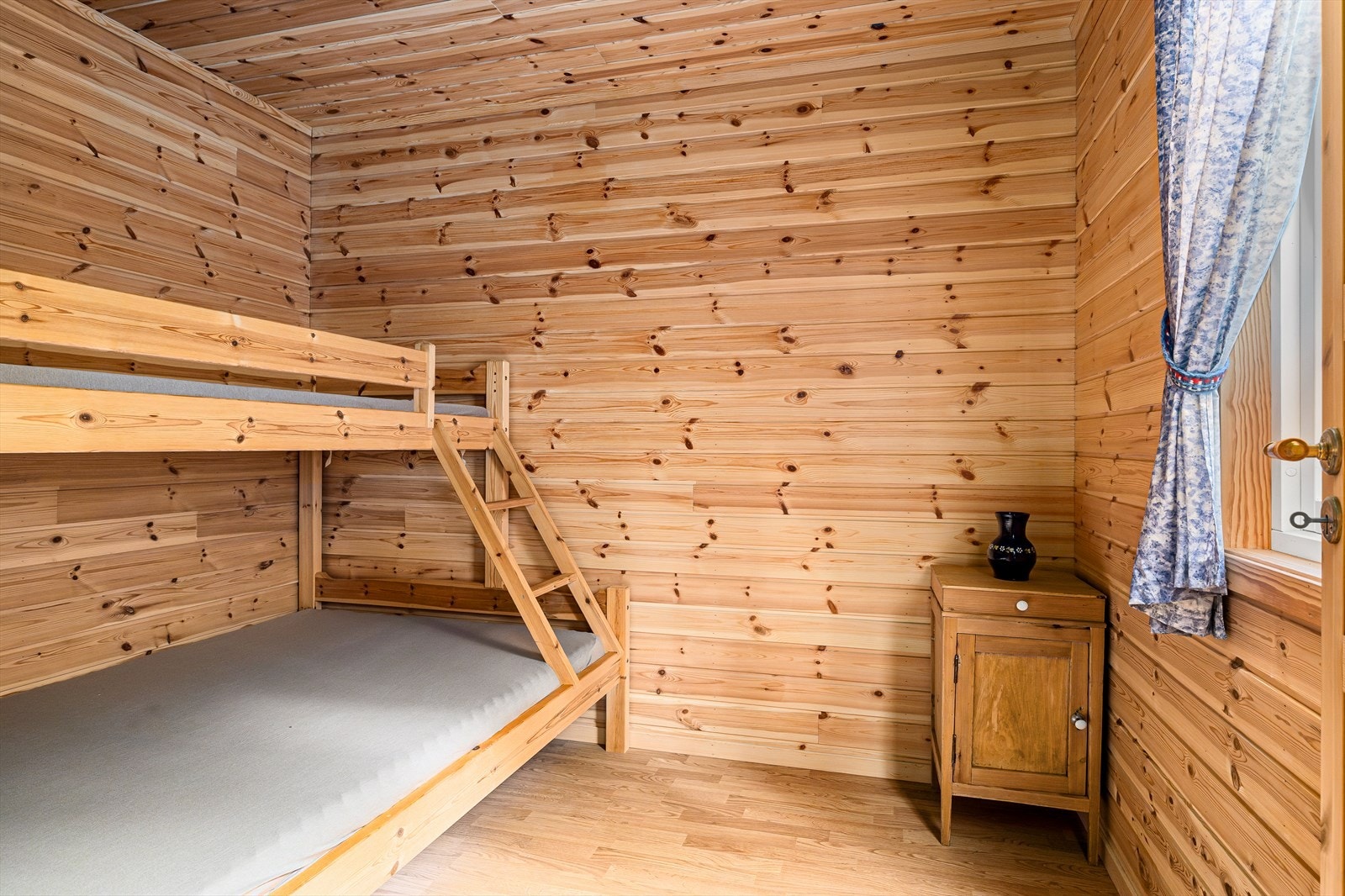 Det andre soverommet, også med klassisk trepanel som gir en varm atmosfære. Galleribilde