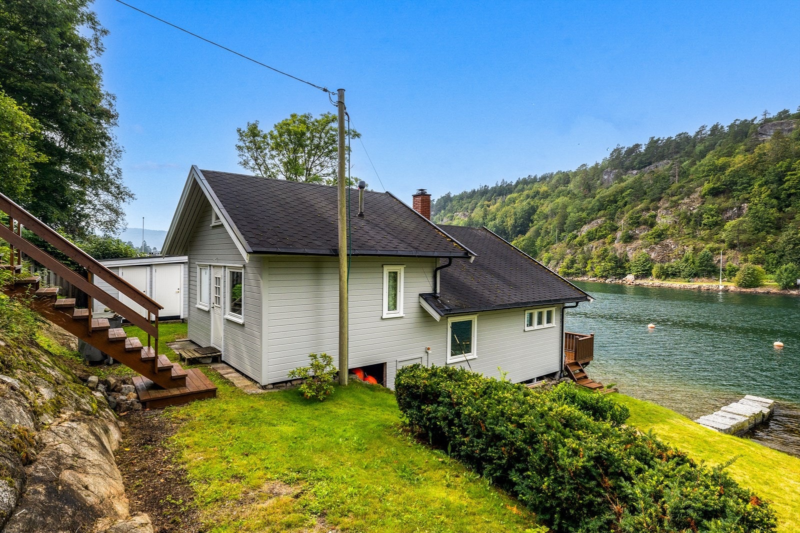 Hyttas bakside med adkomst via trapper i terrenget. Galleribilde