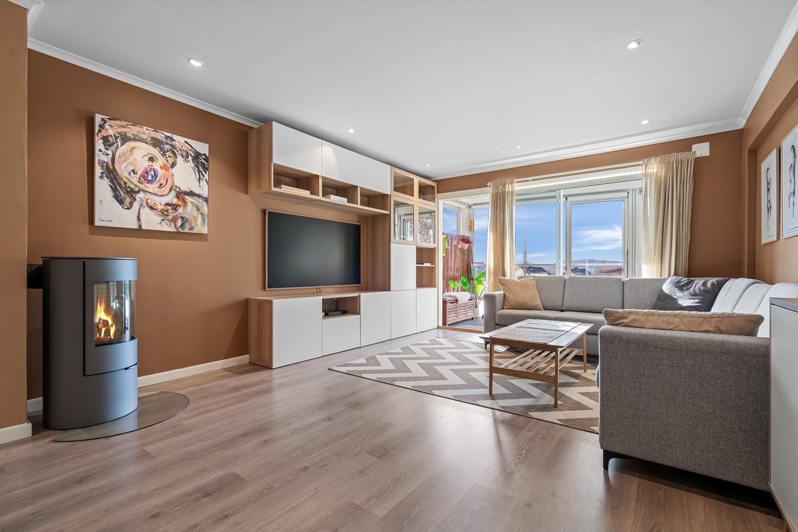 Rommet er malt i en lun fargetone, har ildsted og utstrakt bruk av downlights Galleribilde