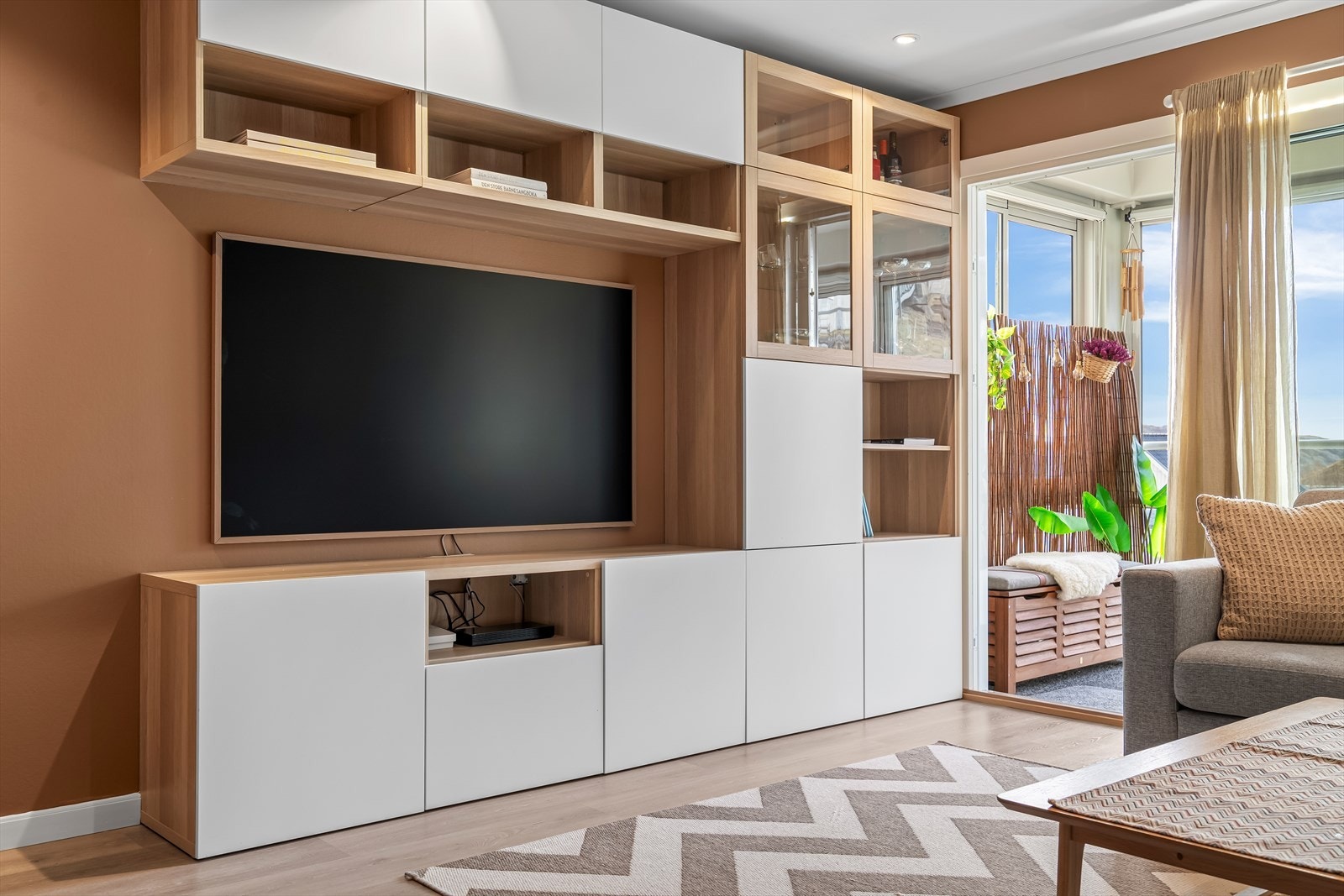 Det veggmonterte hyllesystemet medfølger og består av hyller, skap og egnet plass for TV Galleribilde