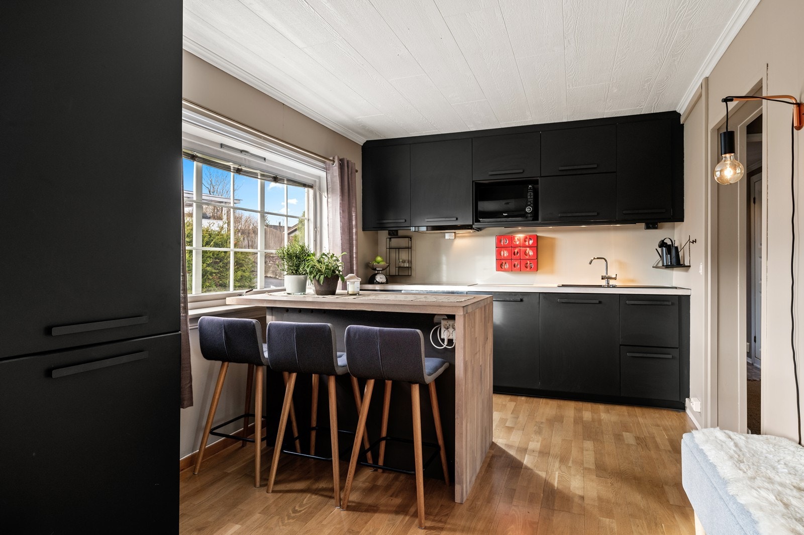 Kjøkkeninnredningen er fra 2018, med glatte fronter og en praktisk kjøkkenøy som fungerer som spiseplass Galleribilde