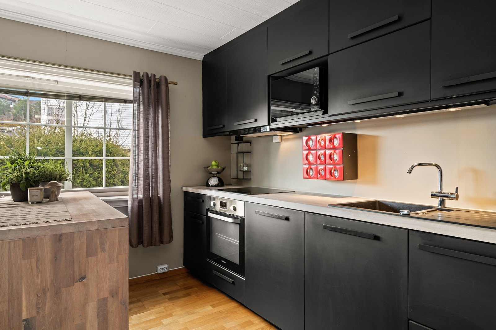 Benkeplaten er i heltre, og kjøkkenet er utstyrt med integrert stekeovn, platetopp, micro og oppvaskmaskin Galleribilde