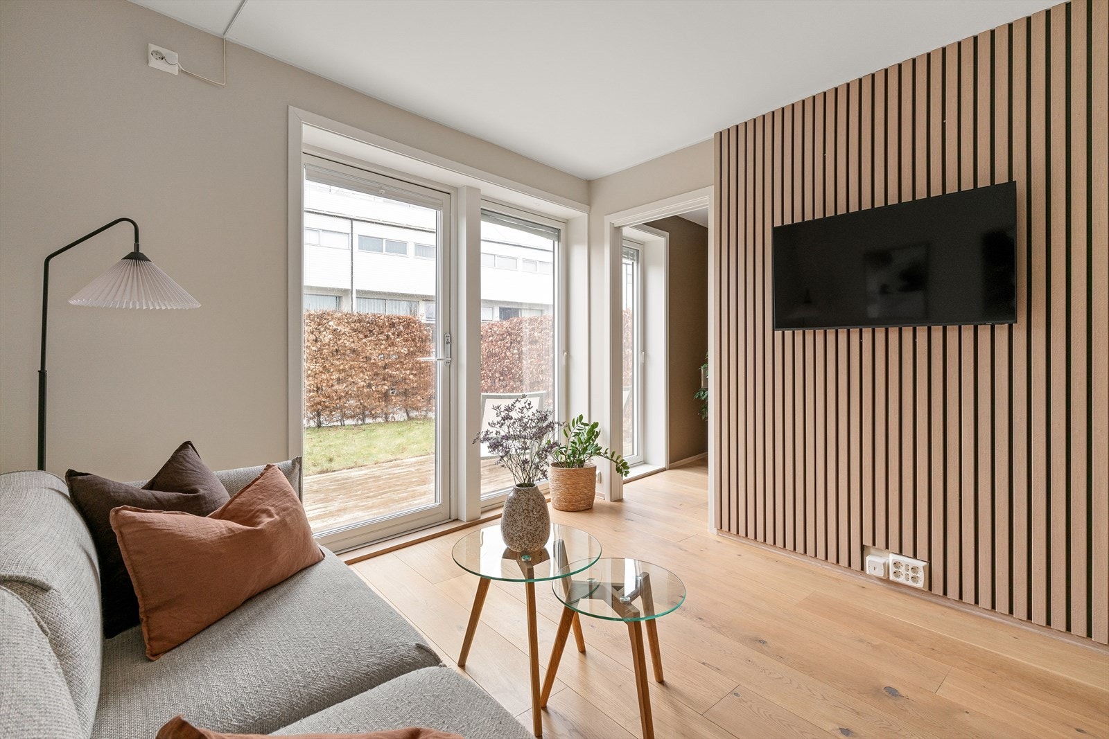 Stue med store vindusflater og godt lysinnslipp, kombinert med dekorativ spilevegg som gir et moderne uttrykk. Galleribilde