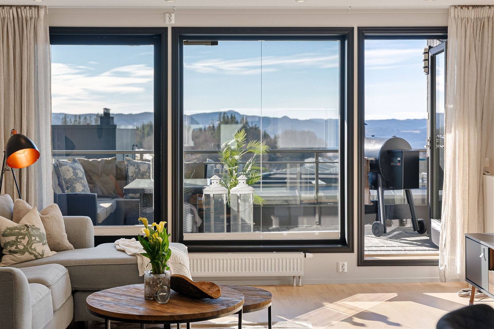 Kombinasjonen av store vindusflater og god takhøyde sørger for en luftig romfølelse. Terrassen utgjør en forlengelse av rommet på sommerstid. Galleribilde