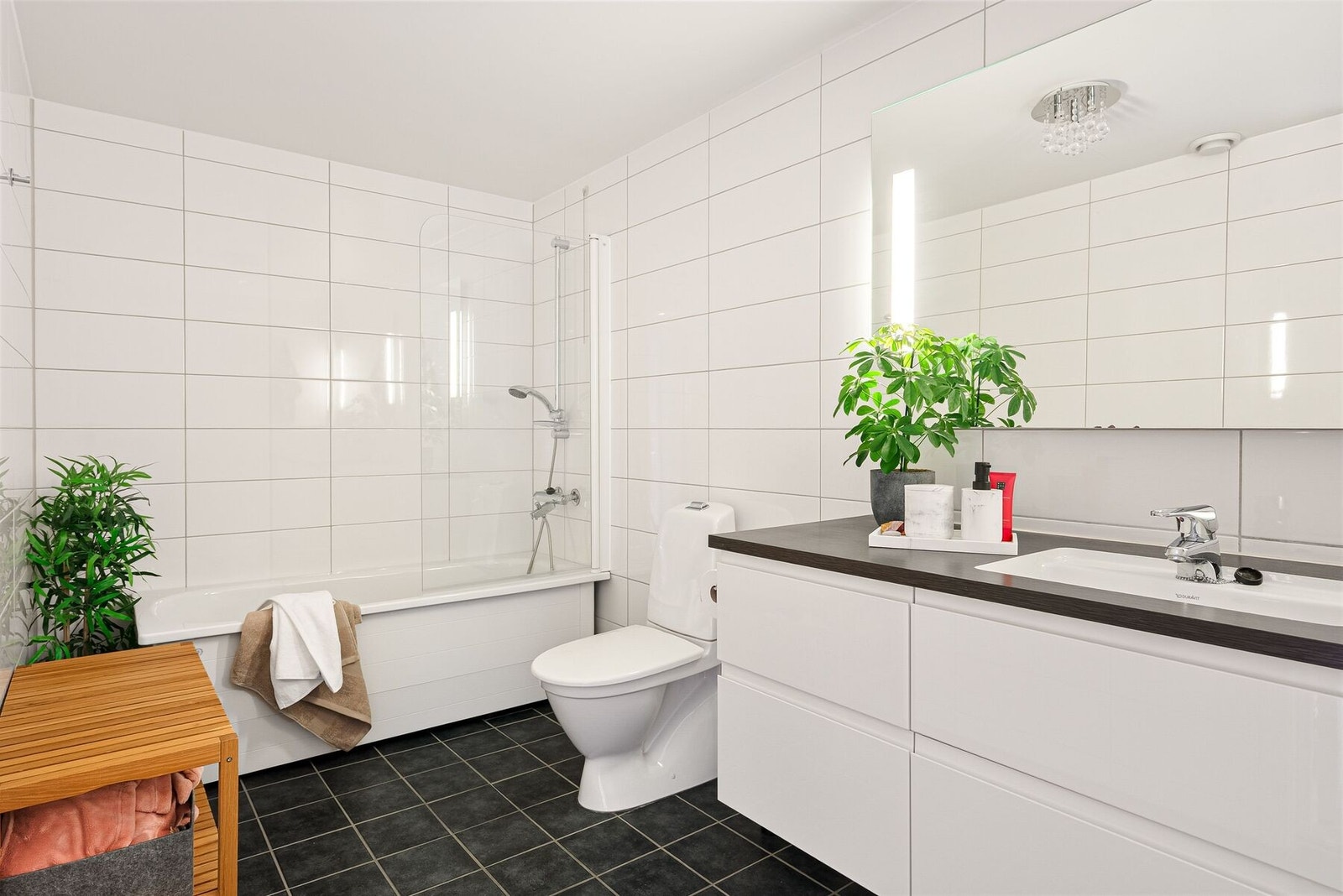 Innbydende bad i underetasjen av god størrelse utstyrt med badekar, dusjgarnityr, servant med innredning med rikelig av oppbevaringsplass og behagelig varme i gulv. Galleribilde