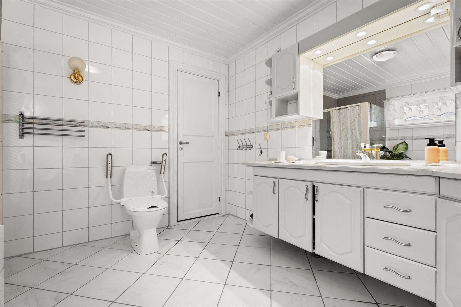 Badet har flislagt og utstyrt med servantinnredning med god oppbevaringsplass. Galleribilde