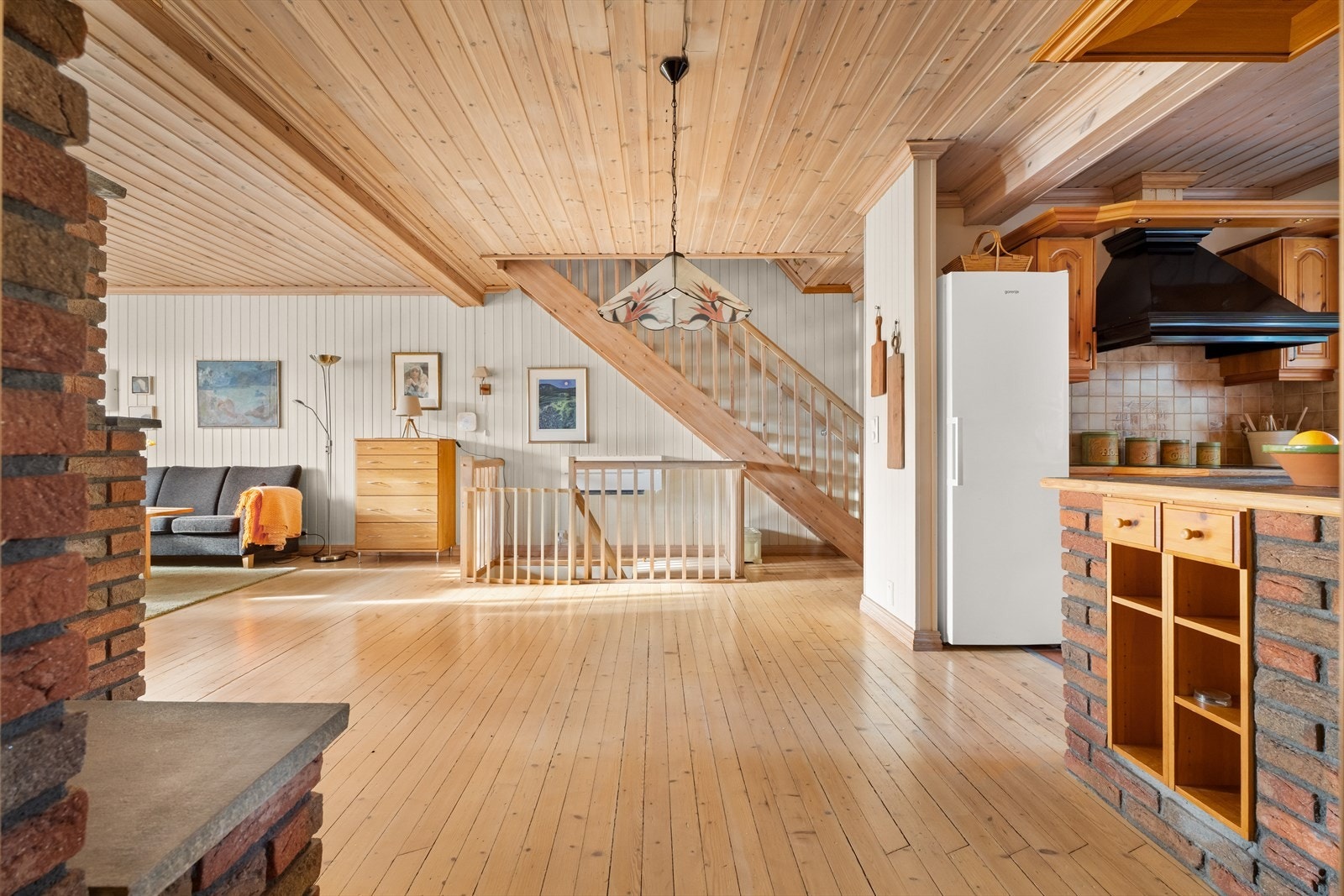 Fra stuen er det en åpen og sosial forbindelse til kjøkkenet, med den lakkerte tretrappen som et sentralt element. Galleribilde