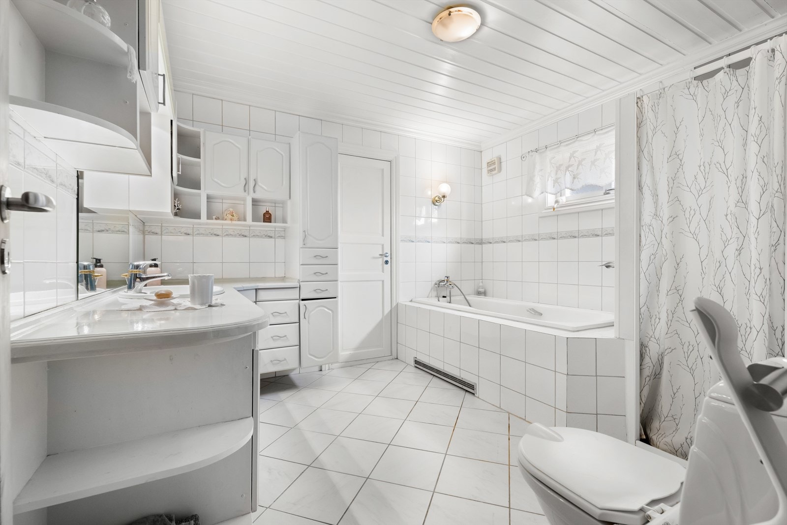 Rommet inneholder både badekar og et dusjhjørne med glassdør. Galleribilde