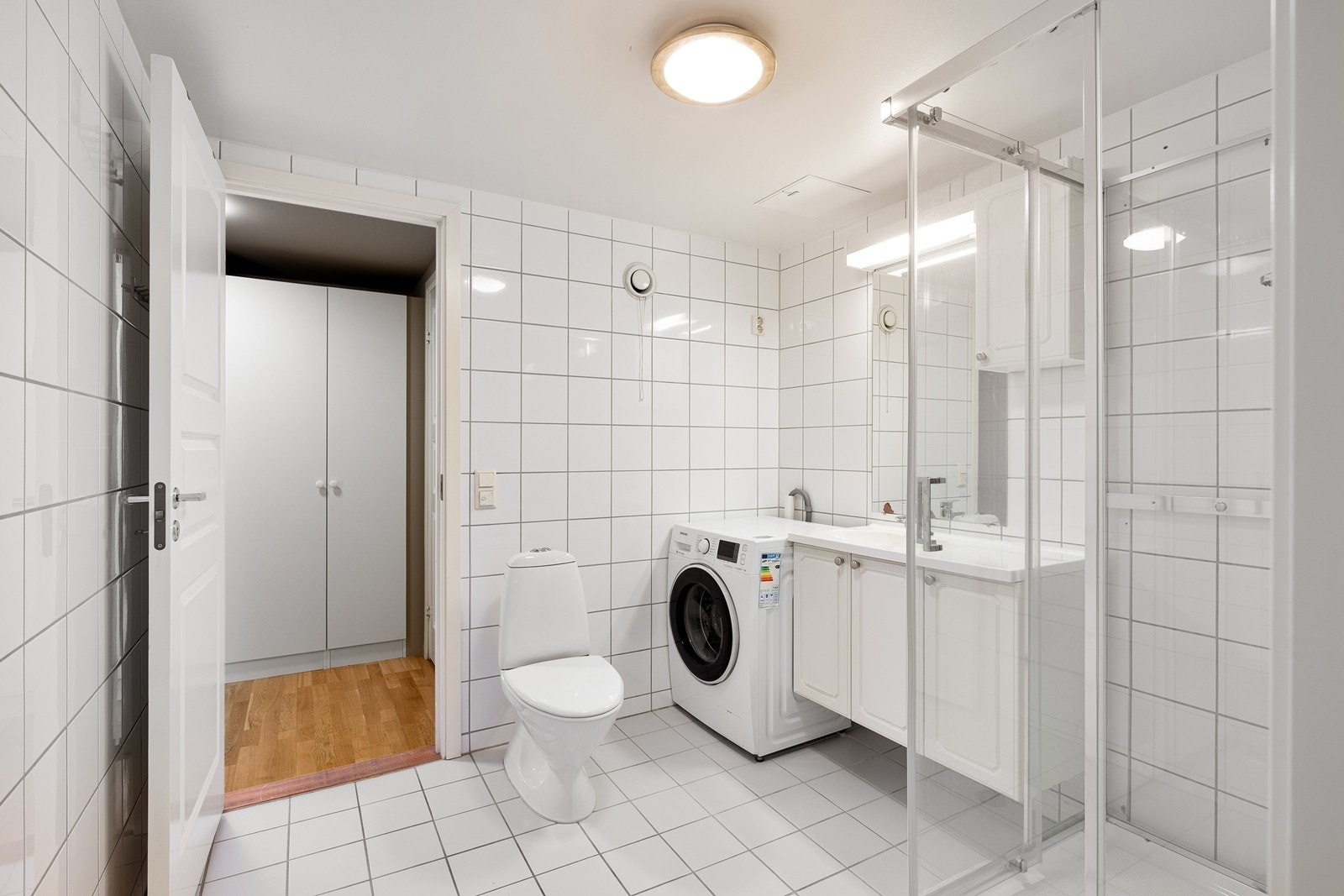 Hovedbadet er helfliset og har gulvvarme, dusjkabinett og opplegg for vaskemaskin. Galleribilde