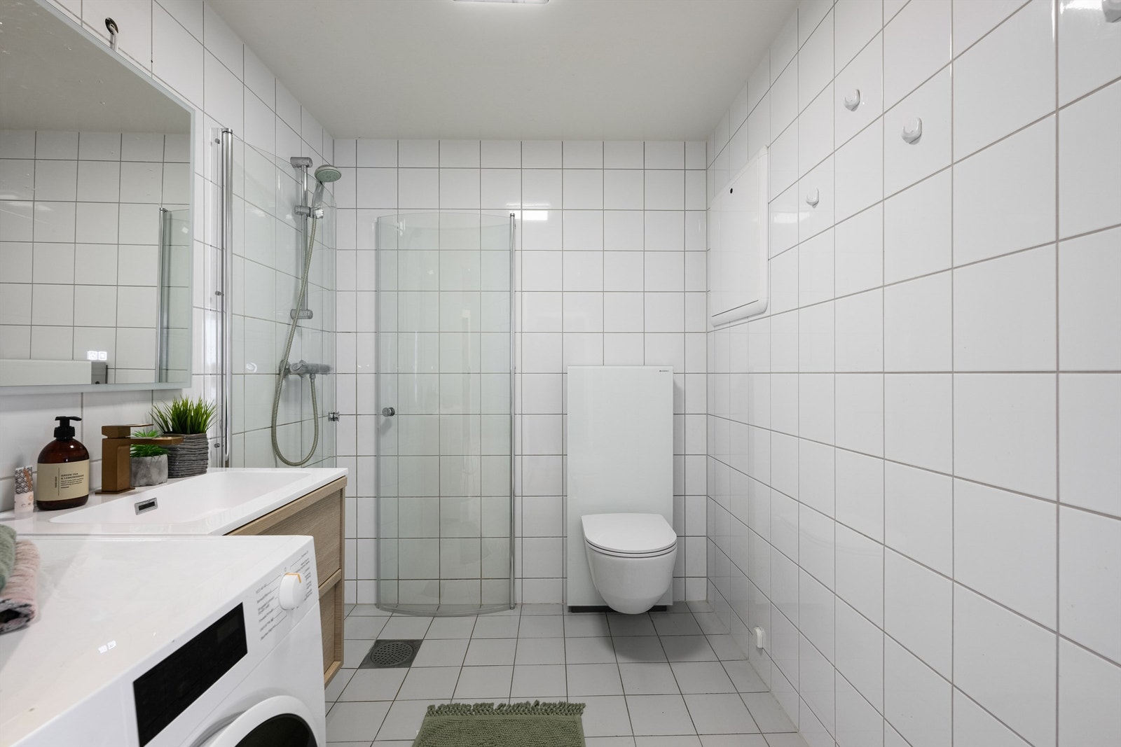 Badet er utstyrt med vegghengt toalett, dusjhjørne og har opplegg for vaskemaskin. Galleribilde