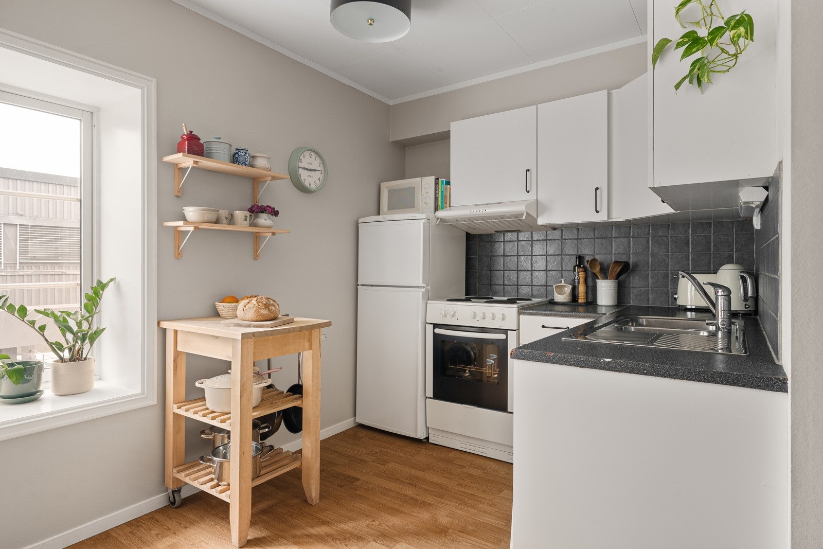 Lyst og praktisk kjøkken med rikelig skap- og benkeplass. Galleribilde