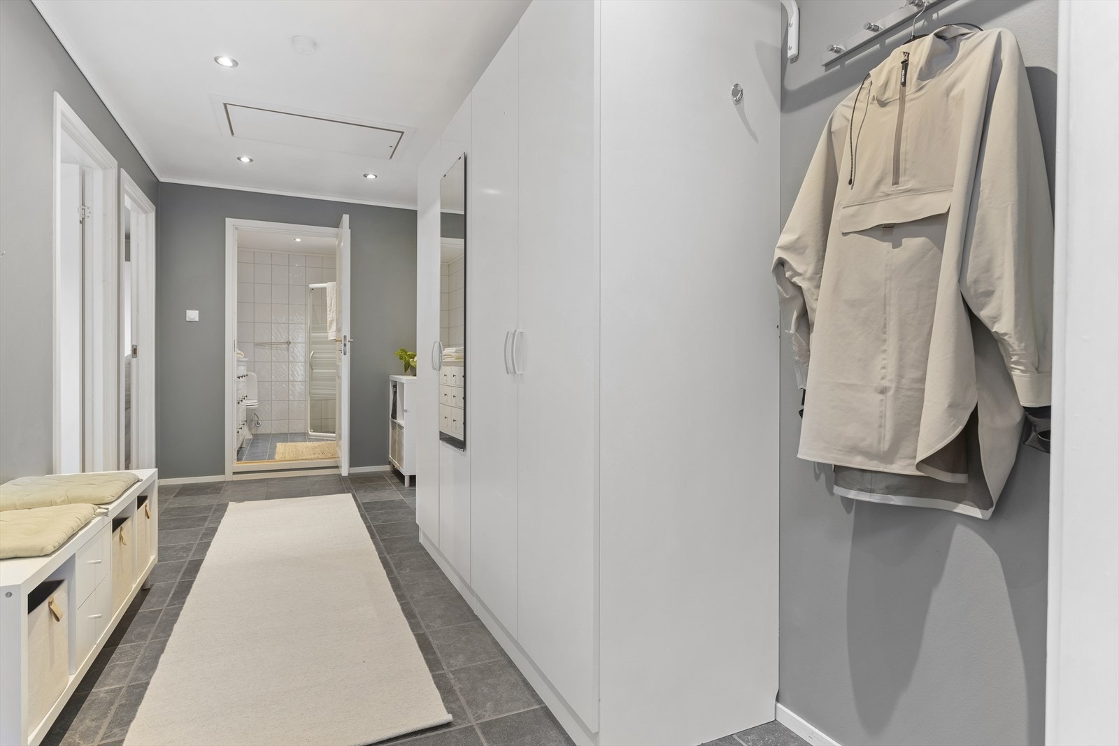 Gangen har flislagt gulv med varmekabler. I taket er det luke til et loft med god lagringsplass. Galleribilde