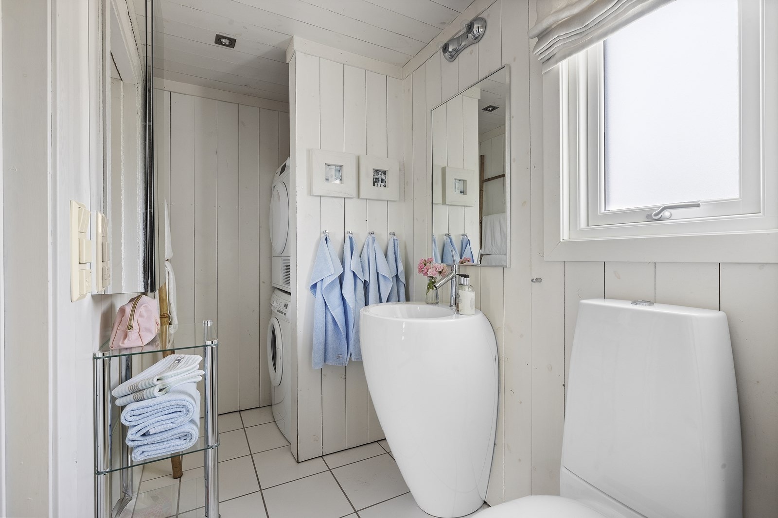 Lyst og praktisk bad med varmekabler, innredet med servant og toalett fra italienske Alessi, samt opplegg til vaskemaskin og tørketrommel. Galleribilde