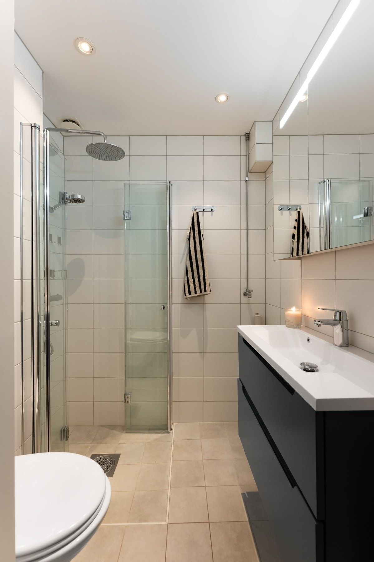 Badet er innredet med servantskap med overliggende servant, speilskap, vegghengt toalett og dushjørne med regndusj og glassvegger, samt opplegg for vaskemaskin. Dersom du ikke ønsker vaskemaskin i leiligheten er det fint fellesvaskeri i kjelleren. Varmtva Galleribilde