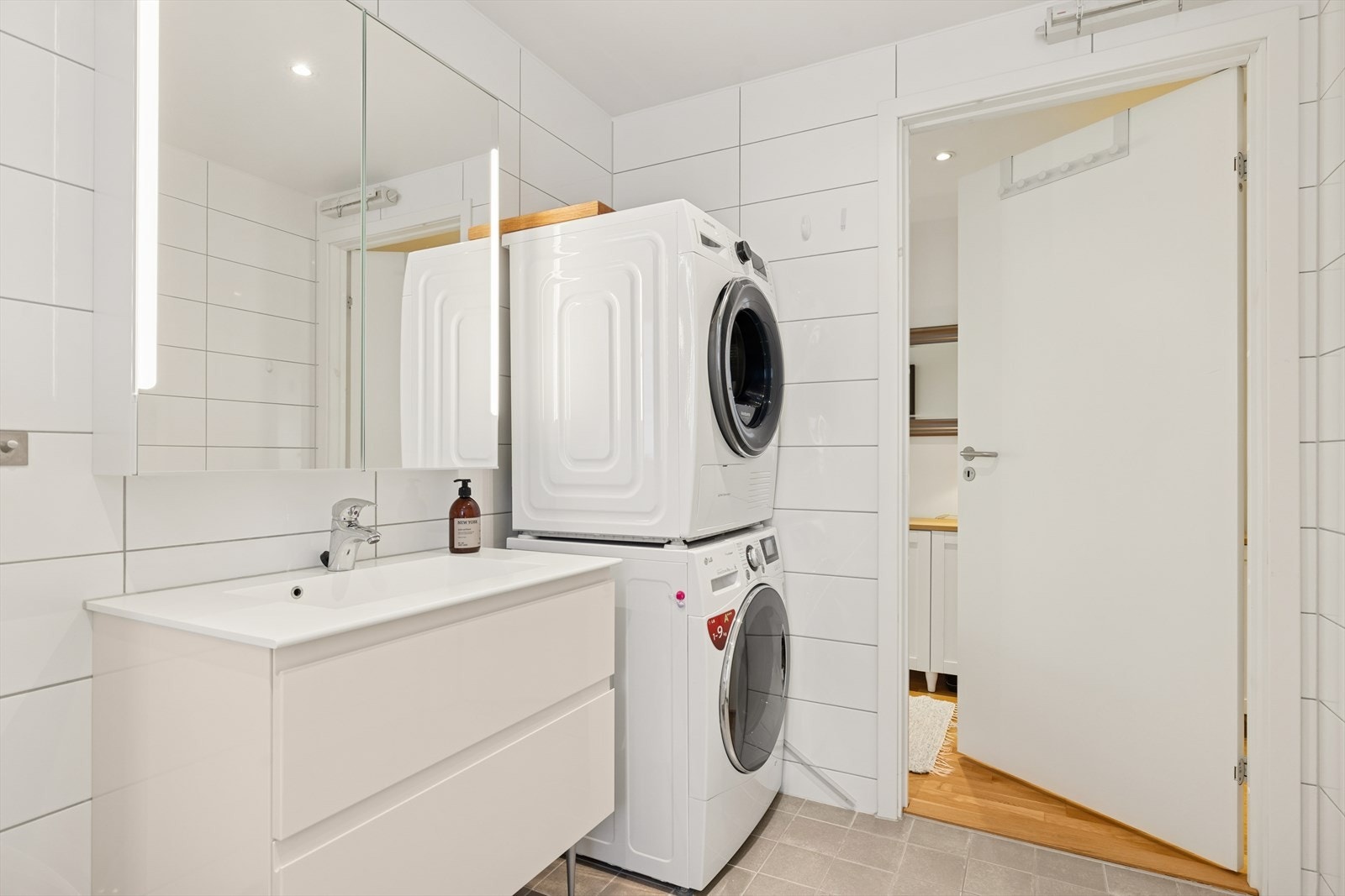 Badekar med dusjgarnityr og plass til vaskemaskin og tørketrommel. Galleribilde