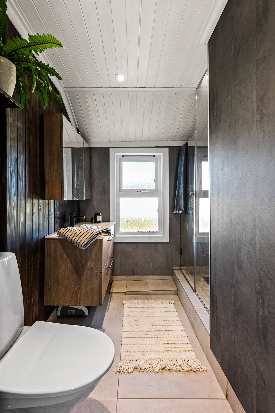 Badet ligger i 2. etasje sammen med soverommene, og ble oppusset i 2020 som egeninnsats. Det er dels fliser og dels plater/treverk på overflatene. Rommet er innredet med moderne baderomsinnredning med skuffer for lagring. Galleribilde