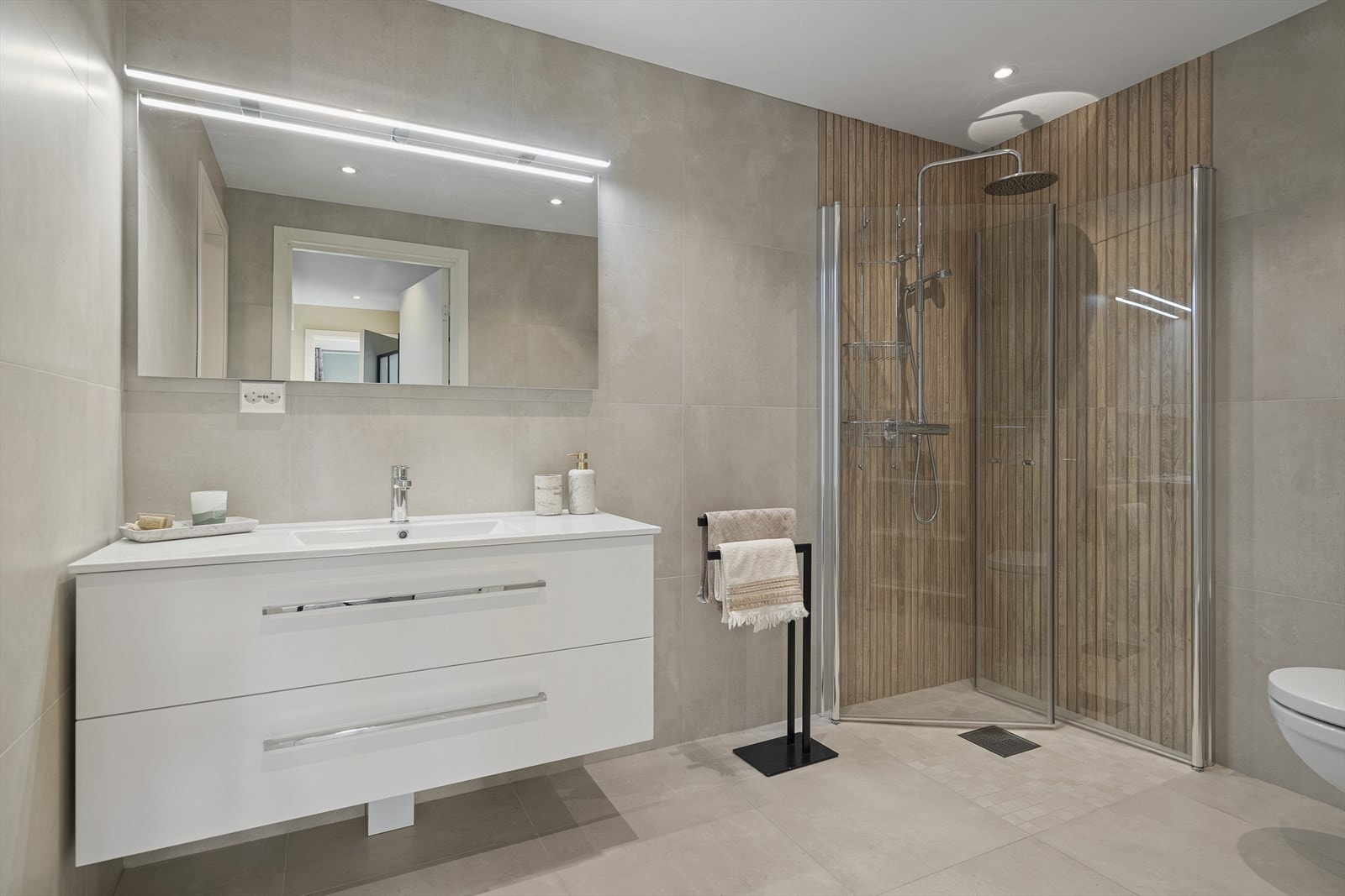 Innredningen består av servant med to romslige skuffer under og vegghengt speil med belysning over Galleribilde