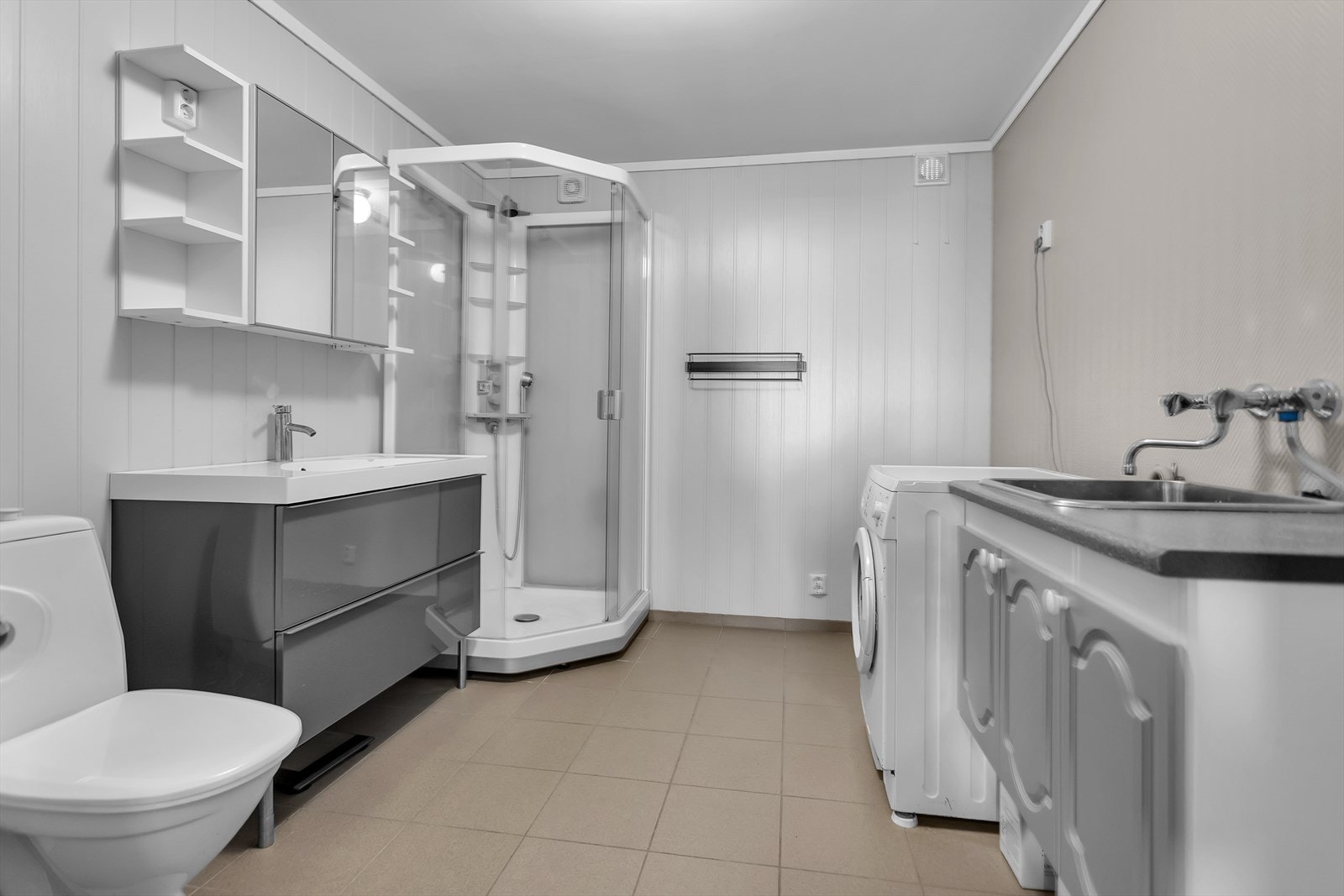Pent bad i utleiedel med utslagsvask og opplegg for vaskemaskin. Galleribilde