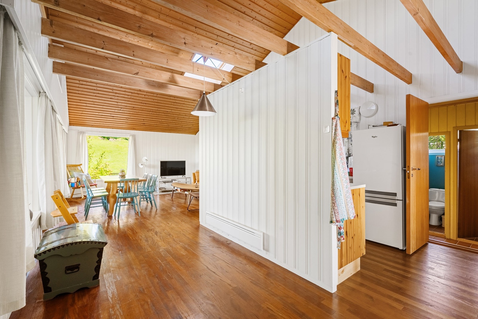 En delvis åpen løsning mellom stue og kjøkken gir en sosial og funksjonell soneinndeling. Galleribilde