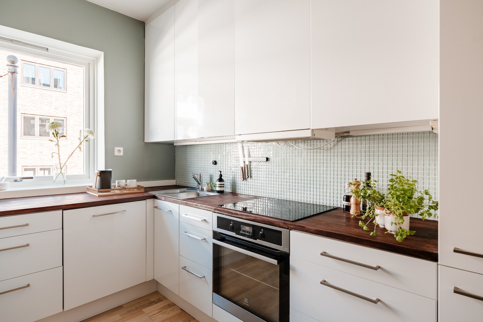 Integrerte hvitevarer er komfyr, induksjonsplatetopp, oppvaskmaskin og kjøleskap med fryser Galleribilde