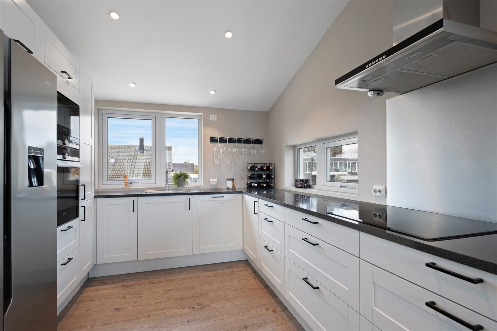 Lyst og tidløst kjøkken med integrerte hvitevarer Galleribilde