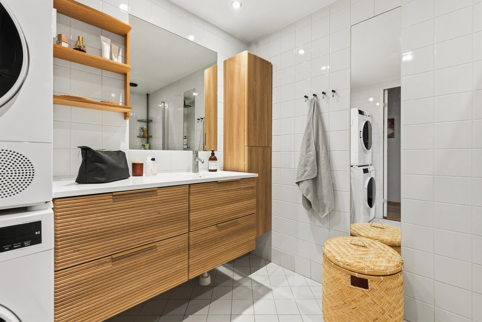 Badet har fliser på gulv og vegger i lyse fargetoner, og det er utstyrt med gulvvarme og downlights Galleribilde