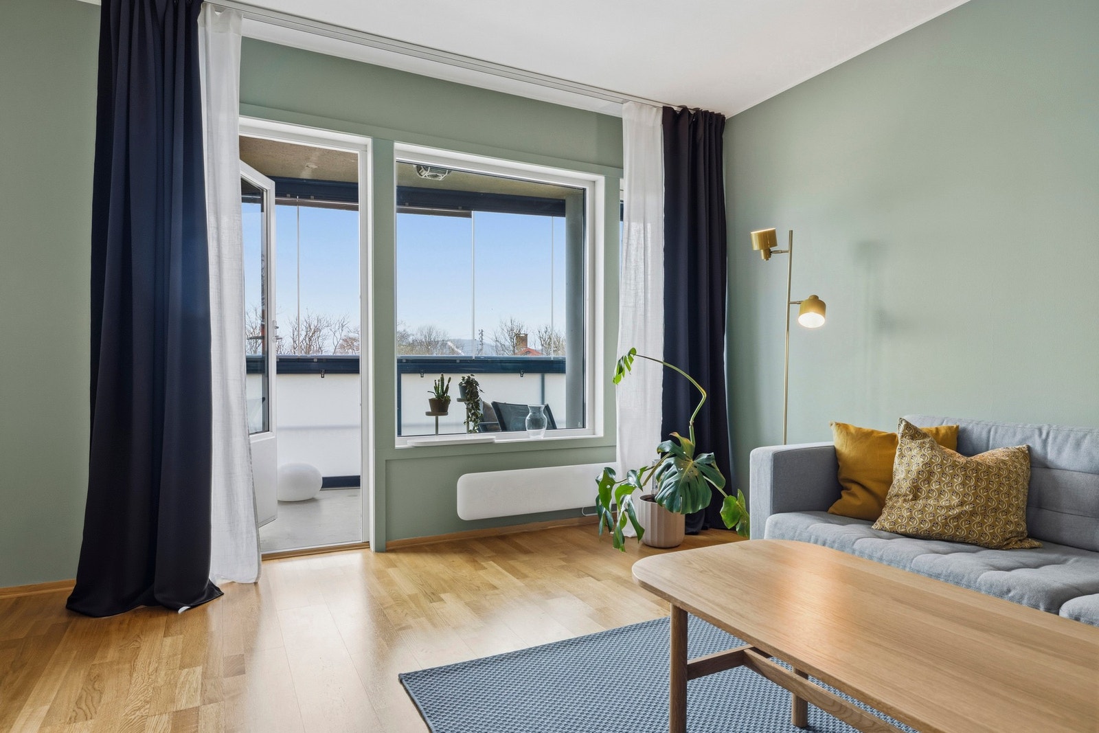 Fra stuen er en glassdør til balkongen og store vinduer som gir masse naturlig lys Galleribilde