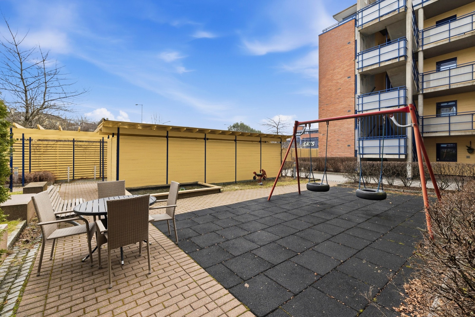 Sameiet har pent opparbeidede utearealer med plen, busker, asfalterte og brosteinsbelagte gangveier, samt sittegrupper og lekeapparater Galleribilde