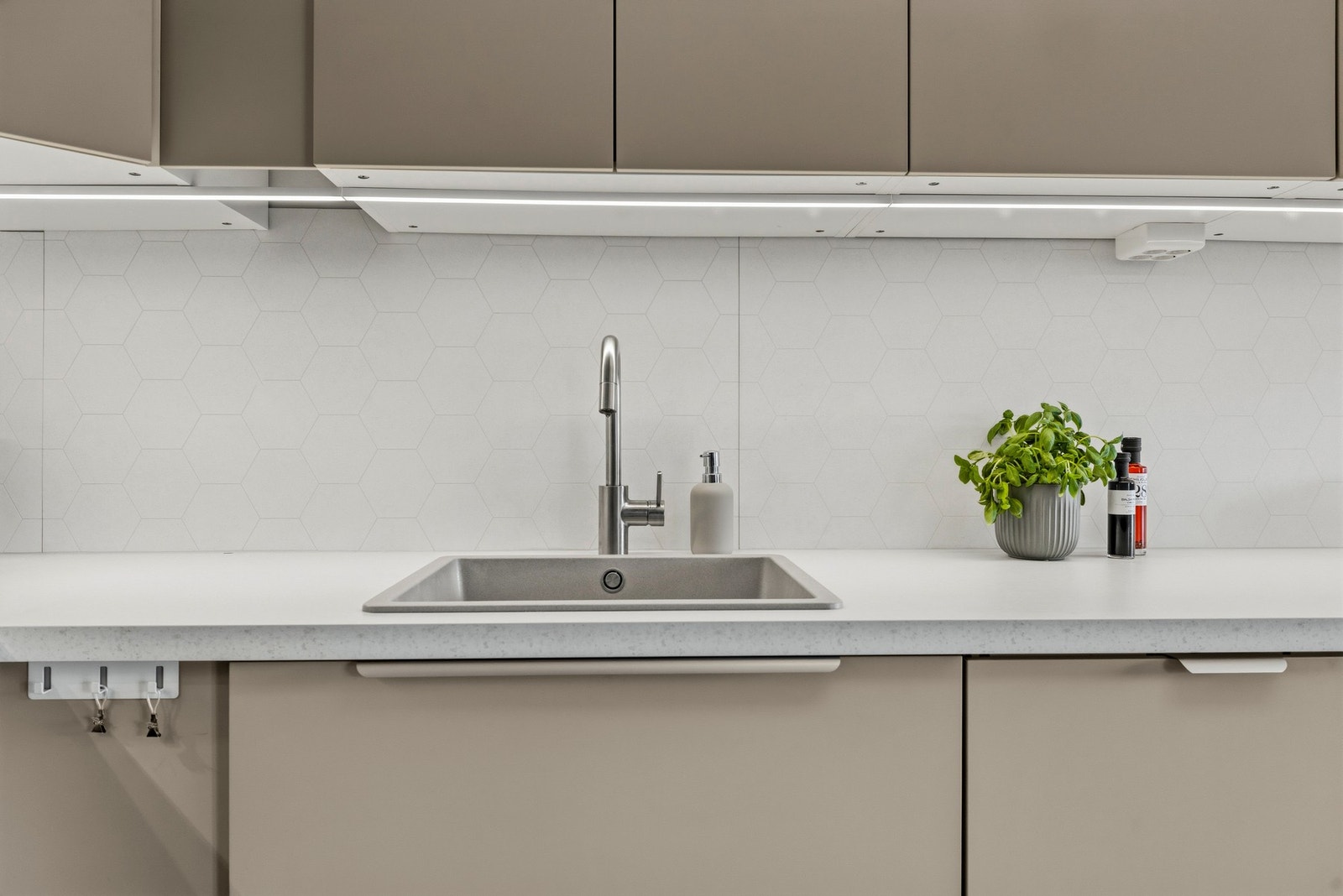 Det er integrerte hvitevarer som platetopp, stekeovn, oppvaskmaskin og kjøl/frys Galleribilde