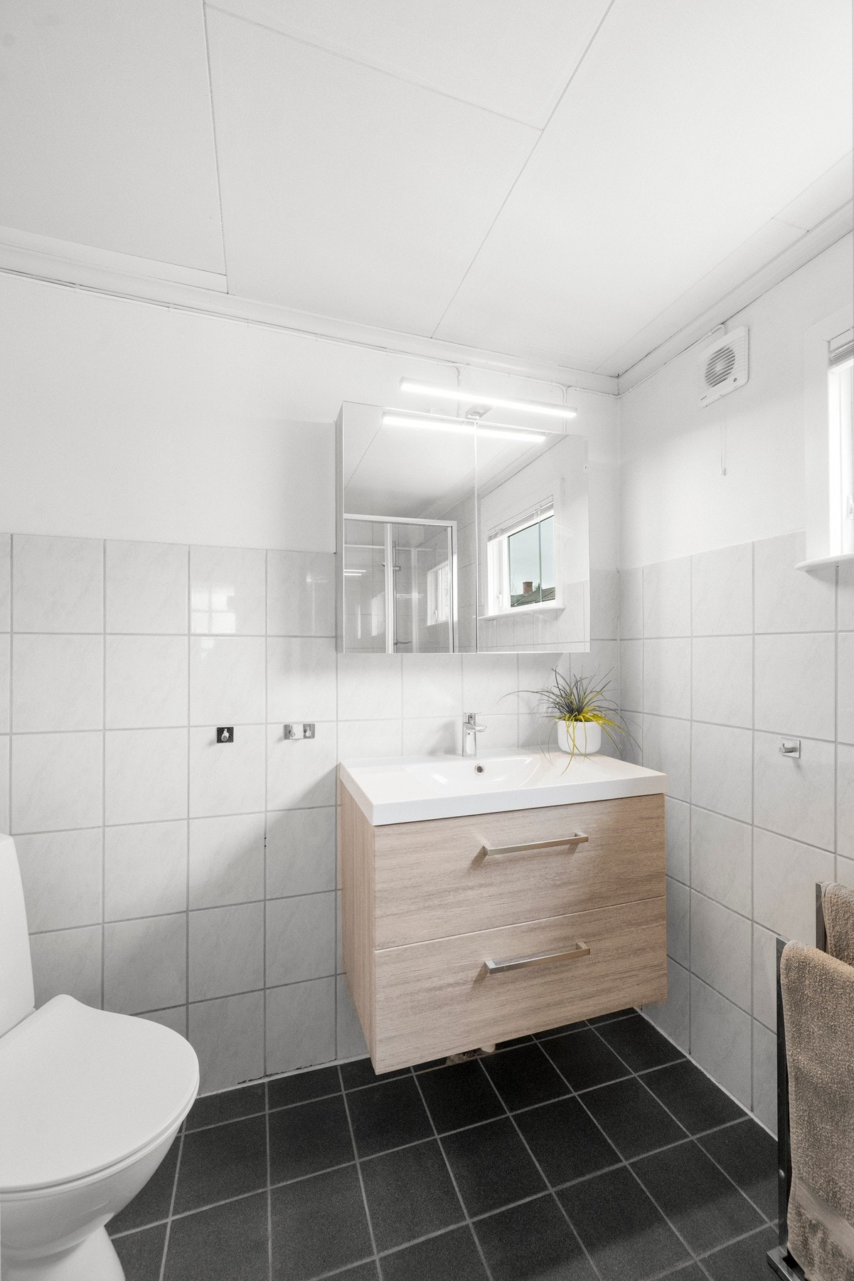 Badet er innredet med servantskap, wc og dusjsone, og har fått ny baderomsinnredning i 2020, med ytterligere oppgradering av toalett i 2024. Galleribilde