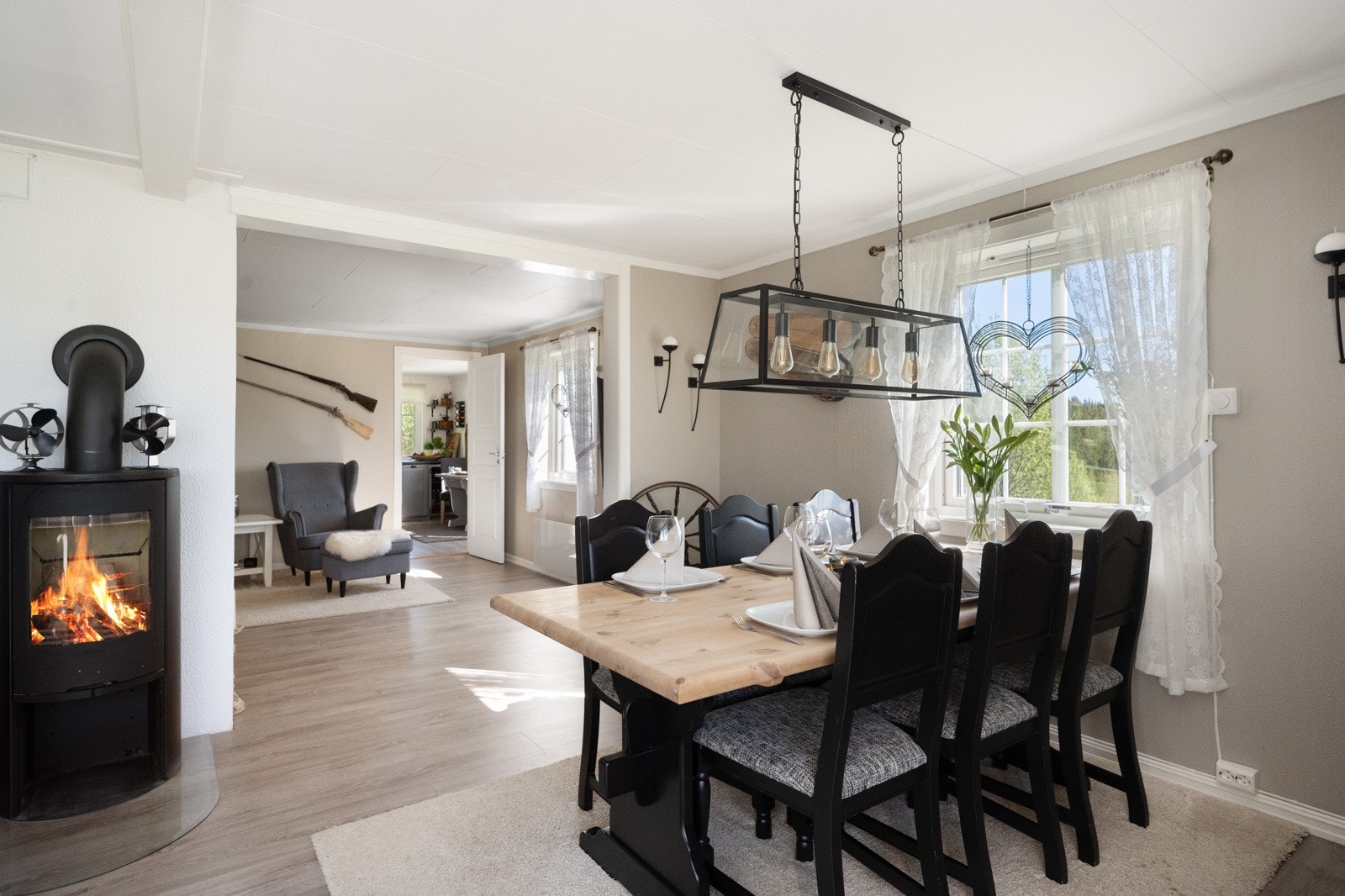 En nyere peisovn med glassdør, installert i 2019, gir både varme og en koselig atmosfære, perfekt for kalde høst- og vinterkvelder. Galleribilde