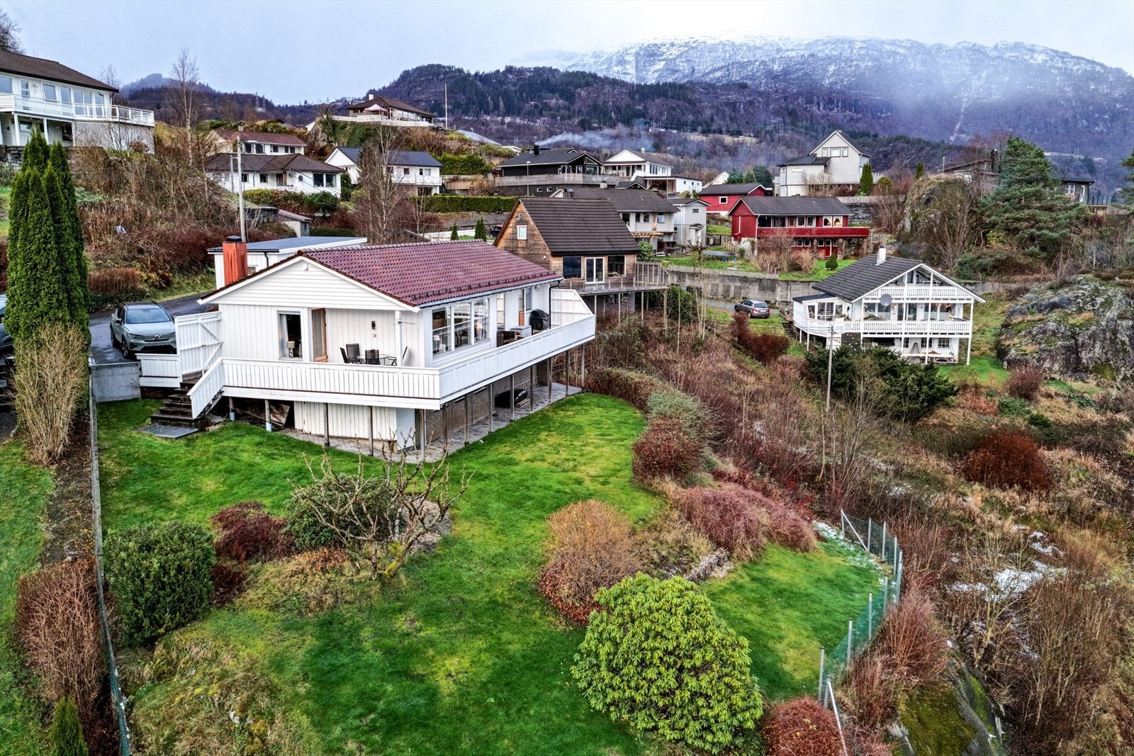 Fasade - pent beplantet tomt med plen, busker og trær Galleribilde