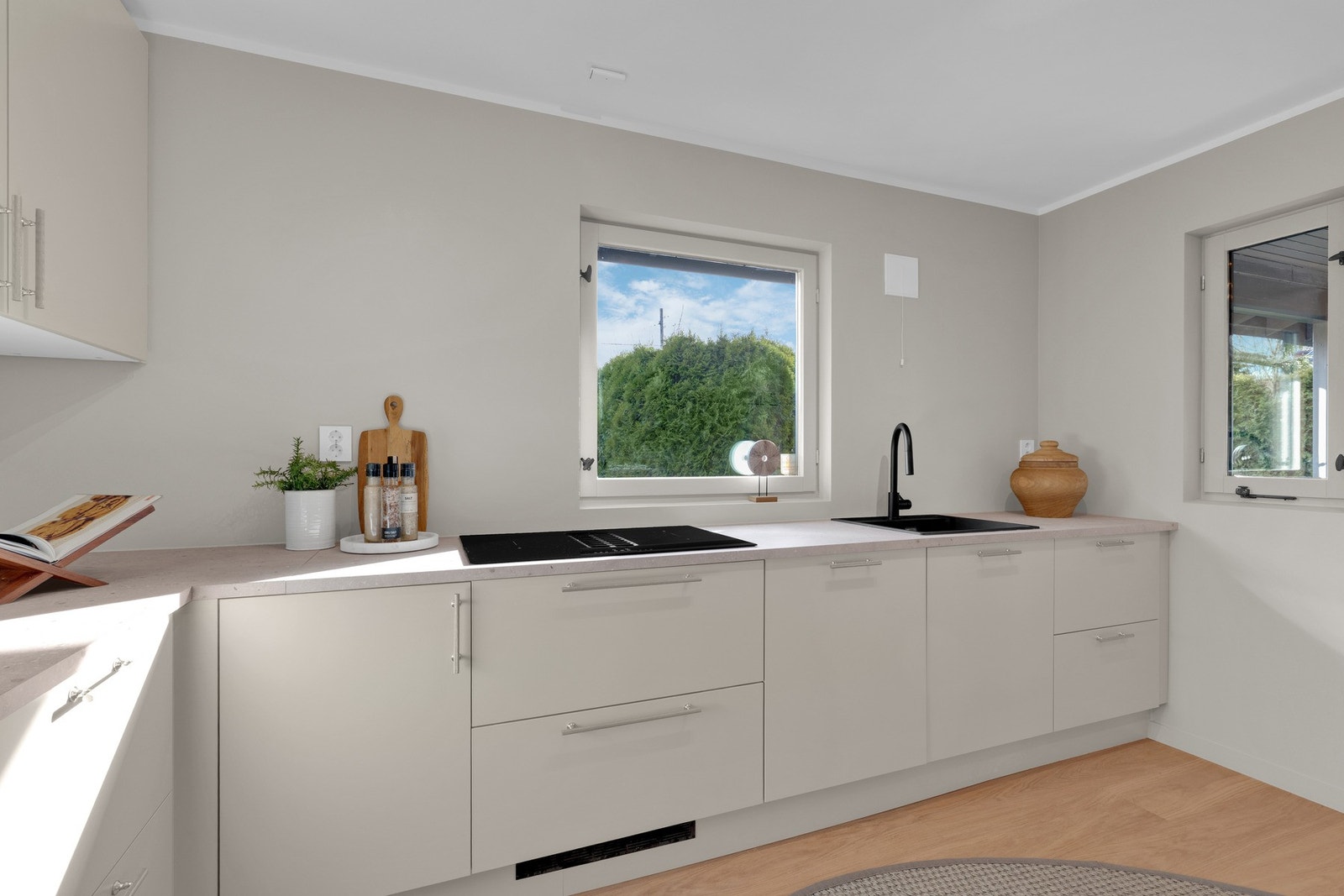 Innredningen har glatte, folierte fronter og laminat benkeplate med nedfelt kum i kompositt/plast. Galleribilde