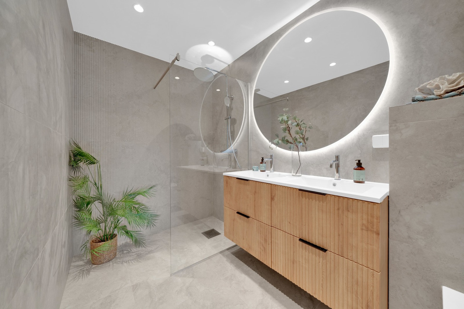 Bad 1 - Badene har flislagte gulv og vegger, og er innredet med dusjsoner med glassvegger, veggmonterte toaletter og servantinnredninger med gode oppbevaringsløsninger. Galleribilde