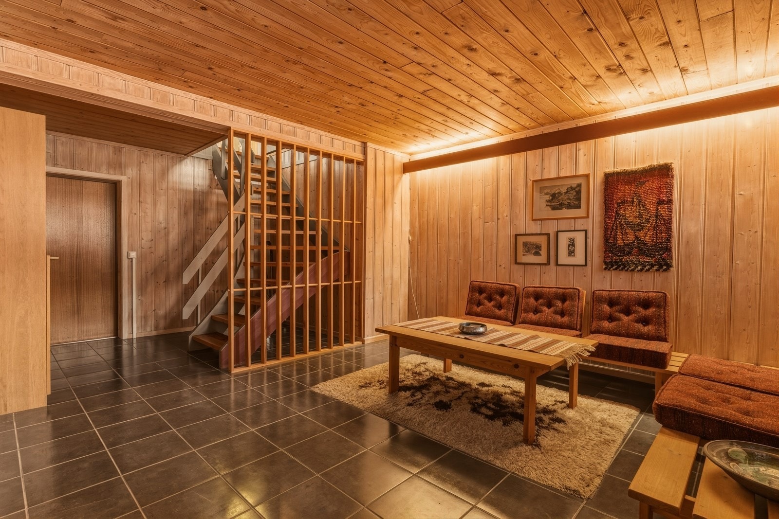 Kjellerstuen i underetasjen fungerer som et svært praktisk ekstra oppholdsrom, perfekt for både avslapning og hverdagsbruk. Galleribilde