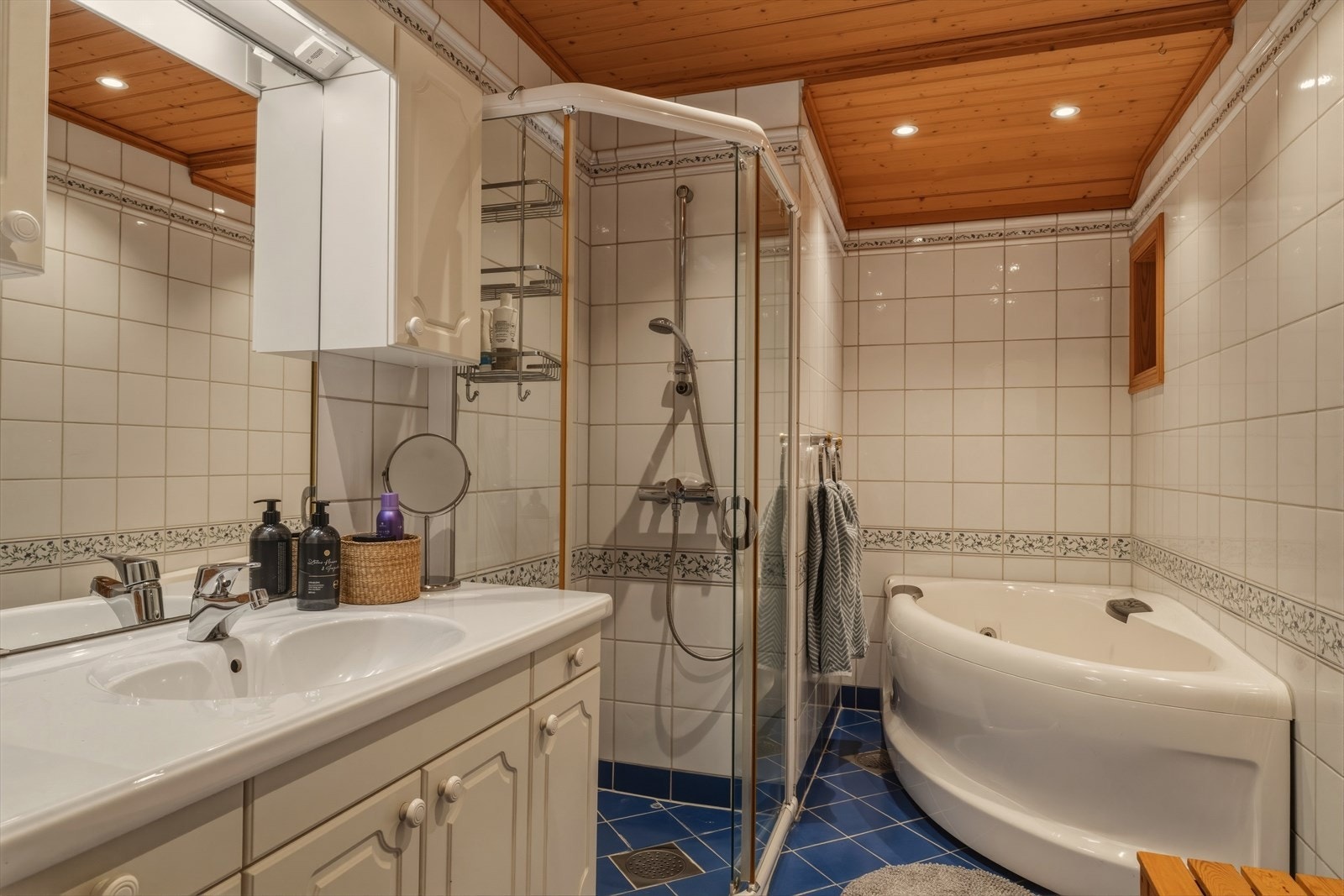 Flislagt bad med varme i gulv. Rommet er funksjonelt innredet med både dusj og hjørnebadekar, samt god oppbevaringsplass i innredningen. Galleribilde